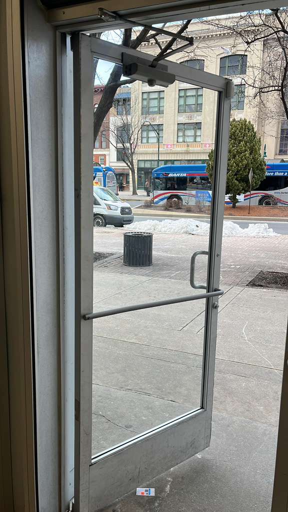 Commercial office entry door with closer and glass panel.